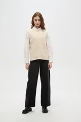 Chaleco de punto texturizado en color marrón chocolate, con cuello redondo y cierre frontal de botones a tono.