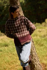 Sweater de punto con diseño de cuadros en tonos bordeaux y chocolate, cuello redondo y puños y ruedo acanalados.