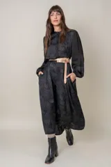 Vestido midi negro con estampado floral, mangas largas abullonadas con puños elastizados, cuello mao y cinturón fino color cobre.