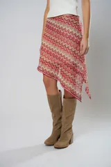 Minifalda asimétrica de crochet con diseño de ondas en tonos rojo, rosa y beige.