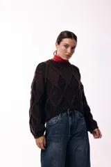 Sweater de tejido de punto grueso con diseño de rombos en relieve, cuello redondo y mangas largas amplias. Presenta una silueta relajada y holgada.