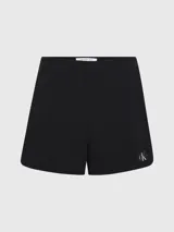 Shorts negros de sirsaca de algodón Calvin Klein, con cintura con cordón, bolsillos con ranura, bolsillos traseros de ojal, forro completo e insignia con el logo de Calvin Klein en el bajo.