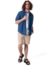 Camisa de manga corta en denim ligero de color azul, con cierre frontal de botones, cuello camisero y un bolsillo en el pecho con solapa y botón.