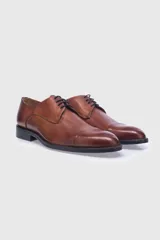 Zapato acordonado de cuero color marrón, con puntera y suela de cuero.