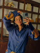 Camisa azul de lino con mangas largas abuchonadas, detalle calado y puños anchos con tiras para atar.