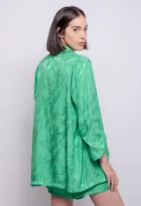 Blazer verde con estampado a tono, de corte recto, con cuello solapa, cierre con botón forrado y bolsillos delanteros.