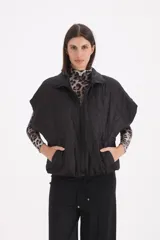 Chaleco acolchado negro con diseño de rombos, cierre frontal con cremallera y bolsillos laterales.