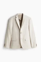 Blazer de lino liviano color beige, con solapas de muesca finas y ojal decorativo. Presenta cierre de dos botones, bolsillo superior, bolsillos delanteros con solapa y dos bolsillos interiores. Tiene botones decorativos en los puños y abertura doble en la parte trasera. Forrado y con corte ajustado.