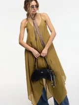 Vestido midi de ramio en color verde oliva, con escote en V, breteles finos y corte evasé con terminación en picos asimétricos.