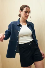 Short negro de gabardina, corte recto, con bolsillos delanteros y traseros, y presillas para cinturón.