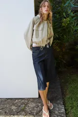 Cazadora color beige con capucha ajustable, manga larga con puño elástico, bolsillos frontales con solapa, bajo ajustable y cierre frontal con cremallera y botones a presión.
