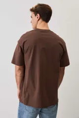 Remera marrón de manga corta, con cuello redondo y diseño holgado.