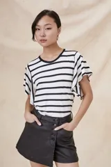 Remera blanca con rayas horizontales negras, cuello redondo y mangas cortas con volados.