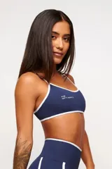 Top deportivo verde con detalles en blanco, logo minimalista y tirantes ajustables. Fabricado en poliamida y elastano con protección UV50+.