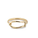 Pulsera rígida dorada con forma de grillete, con cierre de muelle interior.