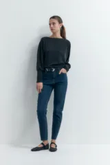 Jean slim de tiro alto color azul oscuro, con corte ajustado desde la cadera hasta el tobillo y largo hasta el tobillo.