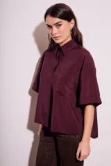 Camisa oversize color borgoña de mangas cortas con puños doblados y bolsillo en el pecho.
