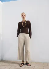 Pantalón crop de lino y viscosa color beige, con diseño recto, cintura elástica y bolsillos laterales.