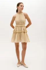 Vestido corto color salmón, con escote halter con volados y falda escalonada con volados.