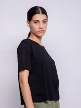 Remera básica de algodón negro, con cuello redondo y mangas cortas holgadas.