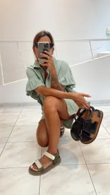 Sandalias planas tipo cangrejeras color verde militar y beige, con suela marrón y tiras ajustables con velcro.