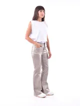 Pantalón de corte oxford con acabado metalizado en tono dorado. Presenta diseño de cinco bolsillos, cierre frontal con botón y cremallera, y pernera ligeramente acampanada.