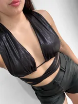 Top negro con escote halter y tiras cruzadas en el abdomen.