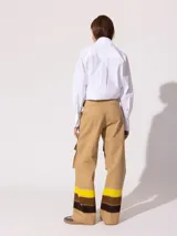 Pantalón cargo wide color beige confeccionado en denim 100% algodón. Posee recortes y bolsillos grandes con tapa en ambas piernas.