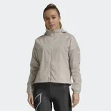 Chaqueta cortavientos 2XU modelo Aero, color beige, con capucha, cierre frontal completo y puños elásticos. Confeccionada en tejido ripstop ligero y resistente al agua.