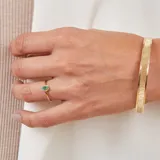 Esclava rígida de oro 18k con acabado satinado y diseño de cinta plana. Presenta una textura fina en su superficie y un diseño minimalista.