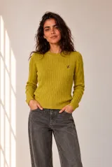 Sweater de punto con diseño de ochos, color verde, de corte clásico, cuello redondo y manga larga, con pequeño bordado en el pecho.