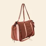 Bolso de deporte color marrón con detalles en rosa claro. Presenta correas de mano tipo cuerda, una correa ajustable para el hombro, un sistema de cordones elásticos decorativos en el frente y bolsillos laterales con cierre.