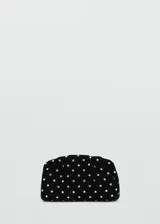 Bolso de mano negro de terciopelo, decorado con pedrería plateada distribuida en toda la superficie y cierre superior.