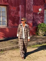 Blazer de corte sastrero con estampado de cuadros en tonos marrones y beige, con solapas clásicas y cierre frontal con botones.