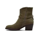 Bota corta de gamuza color marrón, con taco cuadrado y diseño de caña media. Presenta una tira decorativa con hebilla metálica alrededor del tobillo y costuras reforzadas en la parte superior.