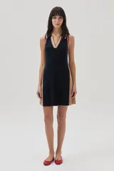 Vestido corto azul marino de tejido de punto, con cuello polo a rayas blancas, beige y rojas, y paneles laterales color beige.