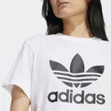 Remera blanca de corte holgado con logo de Adidas trifolio estampado en el frente.