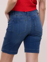 Bermuda de jean azul de calce ajustado con tecnología push up, cinco bolsillos, presillas para cinturón y dobladillo en el ruedo.