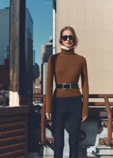 Jersey de punto color marrón con cuello alto vuelto y diseño de corte recto con mangas largas.