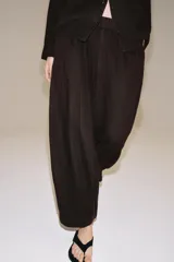 Pantalón de tiro medio confeccionado en lino, con cintura elástica y diseño de pierna ancha tipo barrel. Cuenta con bolsillos laterales.