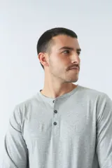 Remera negra de manga larga con cuello redondo abotonado y logo estampado en el pecho.