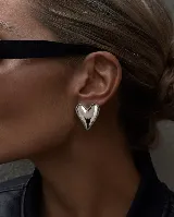 Aros de diseño en forma de corazón con acabado metálico brillante y efecto inflado.