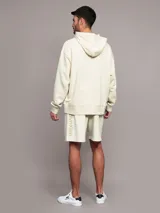 Buzo con capucha Calvin Klein de felpa de algodón color beige, de corte relajado, con bolsillo tipo canguro y logo bordado en el pecho.