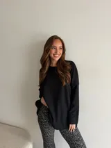 Buzo negro de punto acanalado, de corte oversize, con mangas largas y cuello redondo.