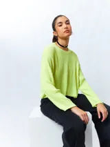 Sweater color crema de tejido de punto acanalado, corte cropped, cuello redondo y mangas largas.