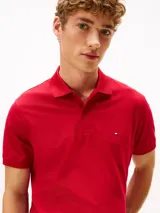 Chomba Tommy Hilfiger de corte regular, color rojo, confeccionada en piqué de mezcla de algodón elástico con tecnología Flex. Cuenta con cuello polo, cierre frontal de dos botones y el logo distintivo de la marca bordado en el pecho.