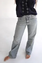 Jean de mujer color celeste claro, de corte recto y tiro medio, con detalles de costuras diagonales en las rodillas y un diseño de doble pretina en la parte frontal.