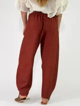Pantalón de lino azul marino con diseño de rayas diplomáticas verticales claras, corte holgado y cintura elástica fruncida.