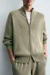 Chaqueta relaxed fit de tejido de punto de algodón, color verde militar, con cuello subido, manga larga, acabados en rib y cierre frontal con cremallera. Presenta efecto lavado.
