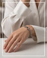 Pulsera de eslabones de acero con dije central en forma de símbolo de infinito.